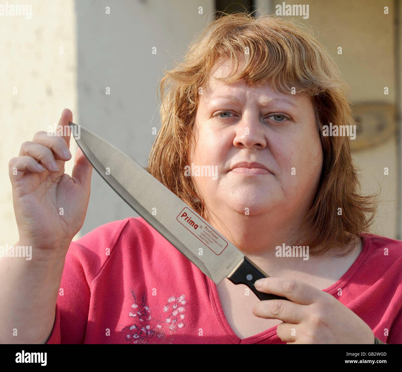 Annette Lewis, die mit einem größeren Messer einen Messerräuber aus ihrem Laden abschreckte, in ihrem Laden in Merthyr Tydfil, heute. Stockfoto