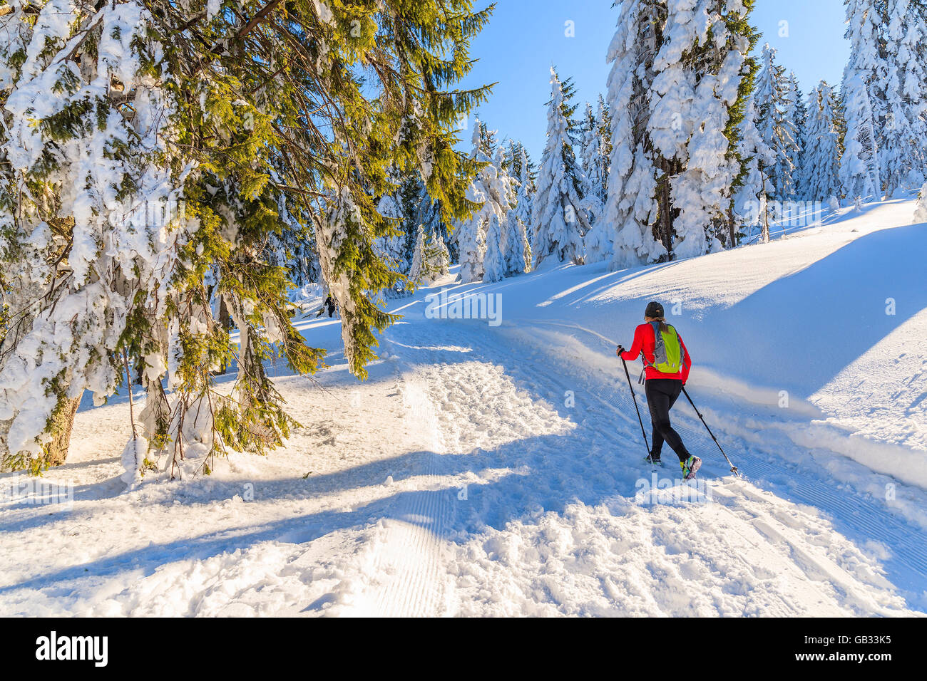 Unbekannte junge Frau mit Rucksack running in Gorce Bergen in der Wintersaison, Polen Stockfoto