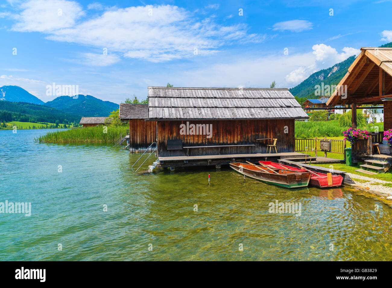 Angelboote/Fischerboote und Holzhäuser am Ufer des Weißensee in Sommerlandschaft Carinthia Land, Österreich Stockfoto