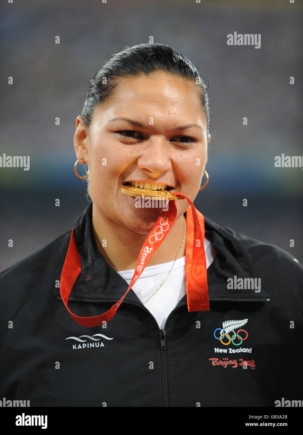 Die Neuseeländerin Valerie Vili beißt ihre Goldmedaille für die Frauenschuss im Nationalstadion von Peking Stockfoto