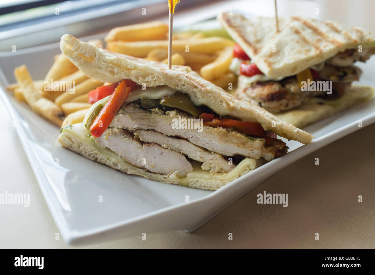 Gegrillten Pesto chicken Panini mit knusprigen Steak frites Cole Slaw und Gurke Stockfoto