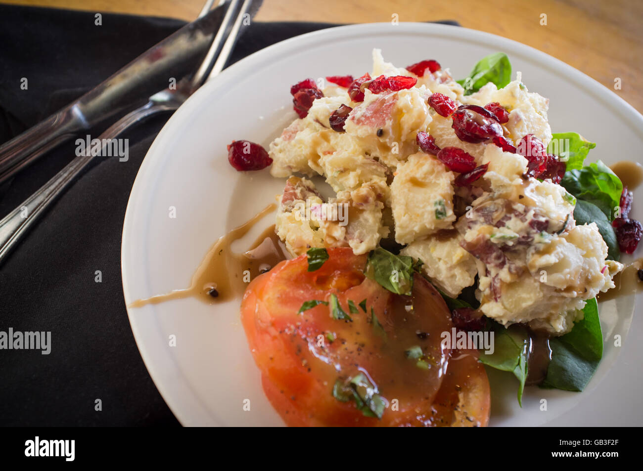 Kartoffelsalat auf Bett aus Spinat Greens mit getrockneten cranberries Stockfoto