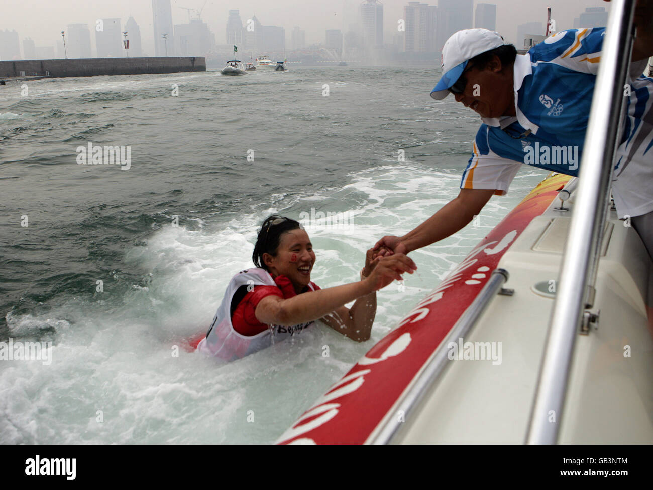 Chinas Laser Radial Bronze Medaille Seemann Sheng Shen wird gerettet, nachdem sie nach der Endrunde ihrer Peking Olympic Wettbewerb vor Qingdao heute über Bord gefallen ist. Stockfoto