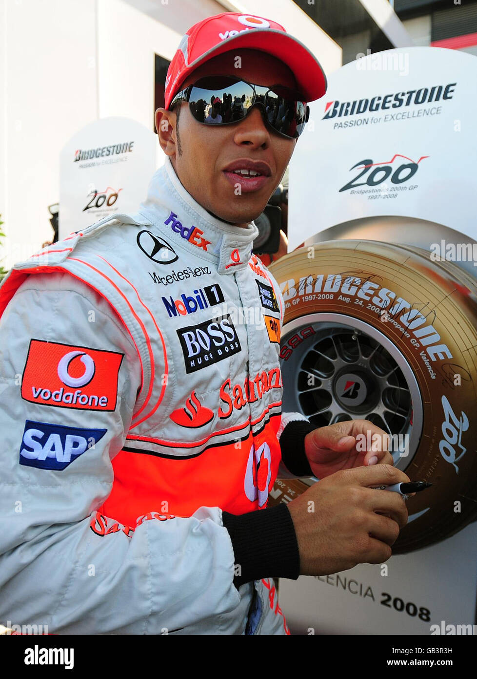 Der britische Lewis Hamilton unterzeichnet einen goldenen Bridgestone Potenza F1-Reifen, um den 200. GP von Bridgstone zu feiern, der an diesem Wochenende den Grand Prix von Europa in Valencia, Spanien, ansteht. Stockfoto