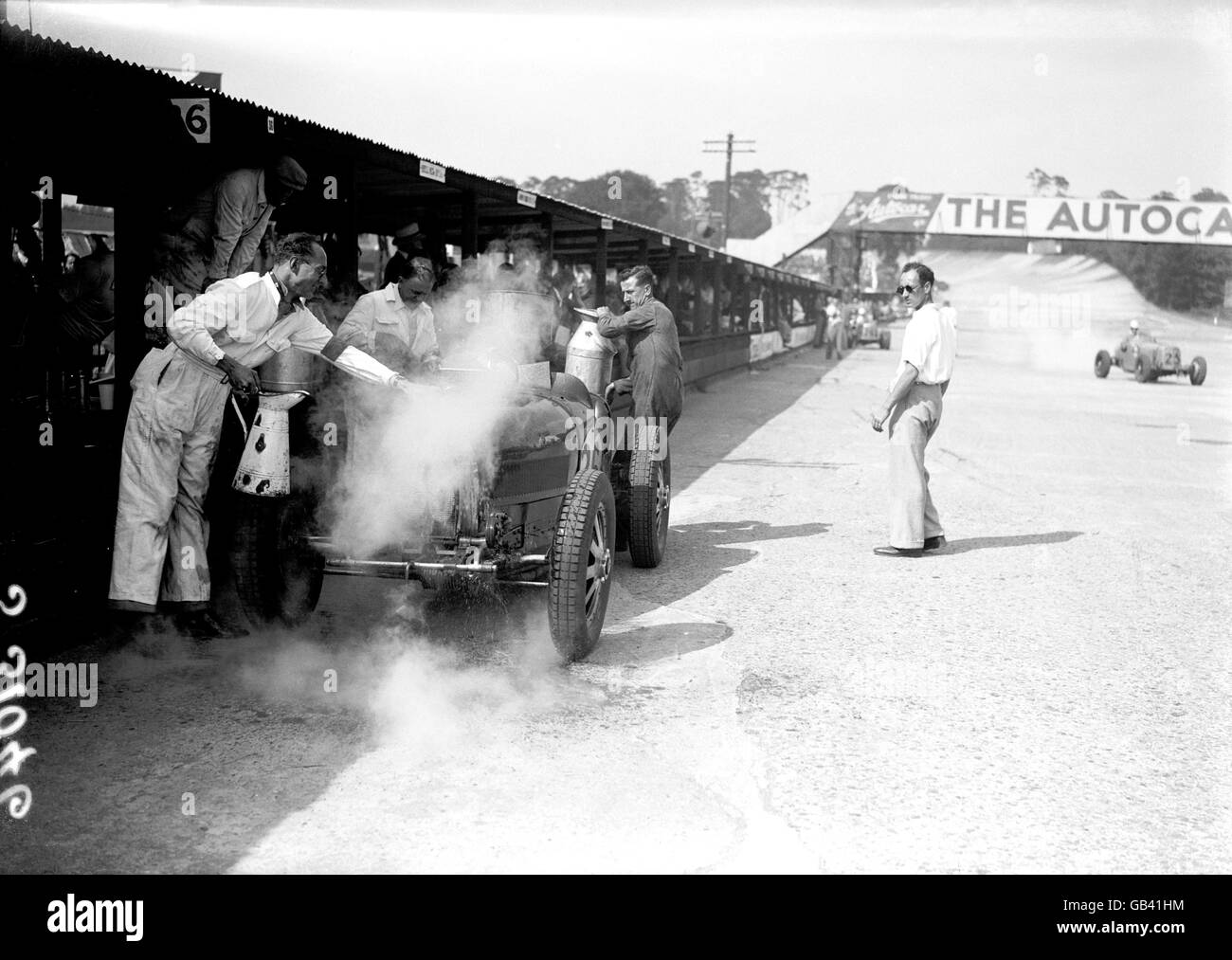 Die Mechaniker versuchen, den Bugatti von Teddy Rayson durch Gießen abzukühlen Wasser auf die Karosserie, nachdem sie überhitzt Stockfoto