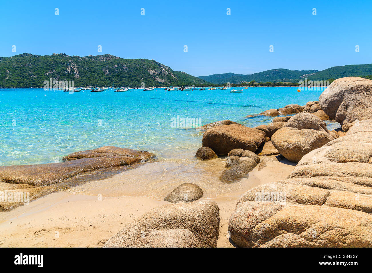 Felsen am Sandstrand von Santa Giulia mit kristallklarem blauen Meerwasser, Korsika, Frankreich Stockfoto