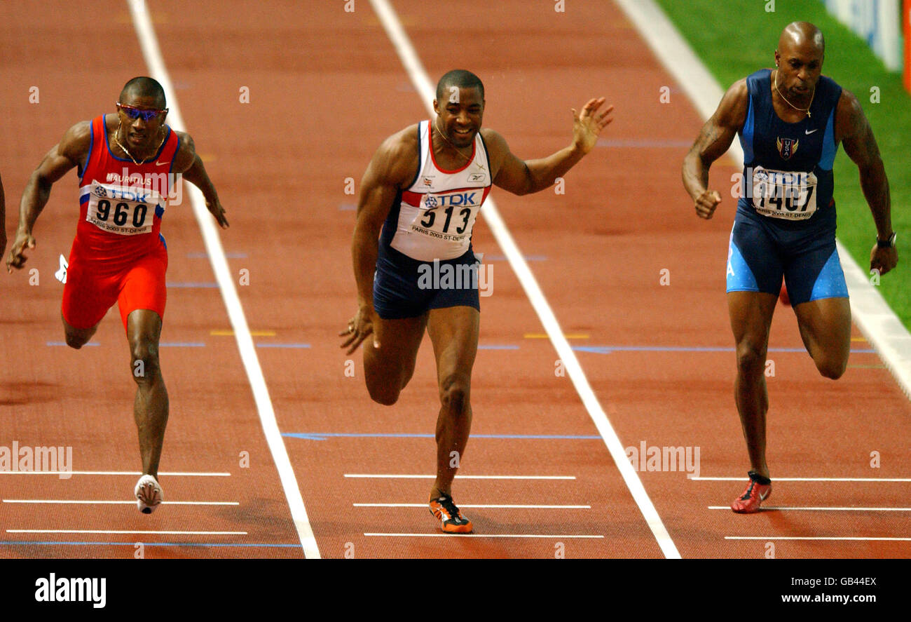 Leichtathletik - IAAF Leichtathletik-Weltmeisterschaften - Paris 2003 - 200-m-Finale der Männer. Der britische Darren Campbell (513) taucht neben Mauritius' Stephane Buckland (960) und dem US-amerikanischen Joshua Johnson (1407) auf die Linie. Stockfoto