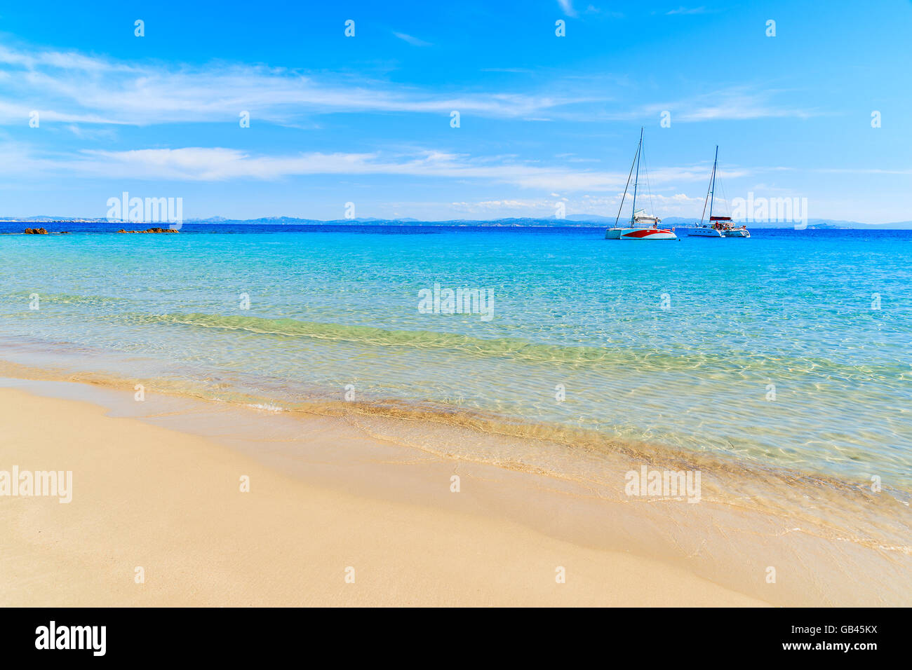 Ein Blick auf Grande Sperone Traumstrand mit kristallklarem blauen Meer Wasser und Katamaran-Boote in Ferne, Korsika, Franken Stockfoto