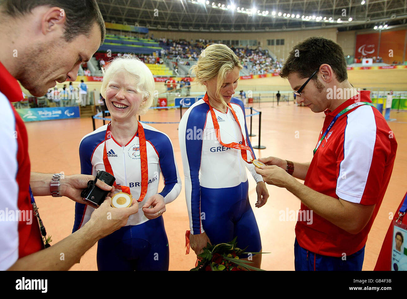 Das britische Tandem-Paar Aileen McGlynn (links) und Ellen Hunter feiern mit ihrem Support-Team, nachdem sie bei den Paralympischen Spielen in Peking 2008 in China beim 1-Kilometer-Zeitfahren der Frauen im Laoshan Velodrome Gold gewonnen haben. Stockfoto