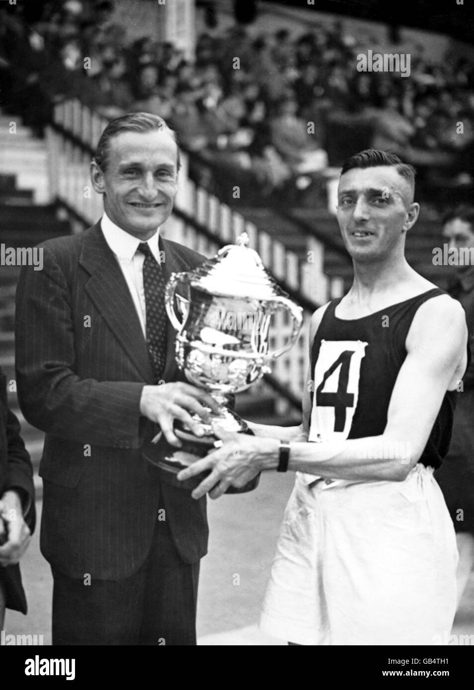 Lord Burghley überreicht die Trophäe Jack Beman, dem Sieger des Marathons Stockfoto