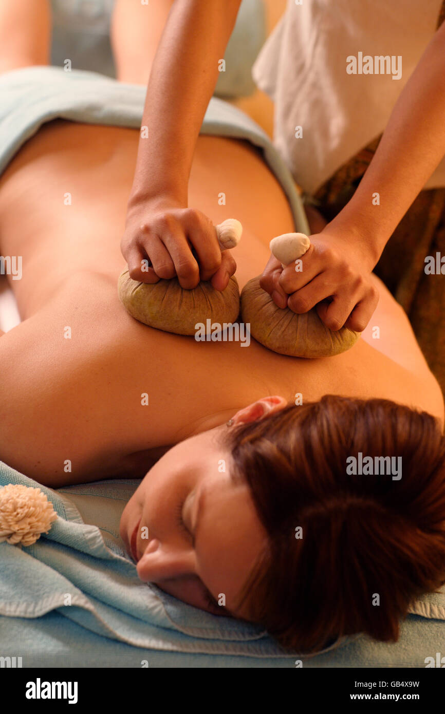 Frau, 35, hat eine heiße Kompresse herbal Massage, Ayurveda-Behandlung Stockfoto