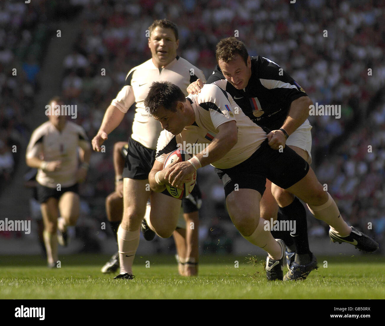 Rugby Union - Hilfe für Heroes Charity Match - Hilfe für Heroes XV gegen International XV - Twickenham. Kenny Logan wird von Alex Goode während des „Help for Heroes“-Spiels in Twickenham, London, in Angriff genommen. Stockfoto