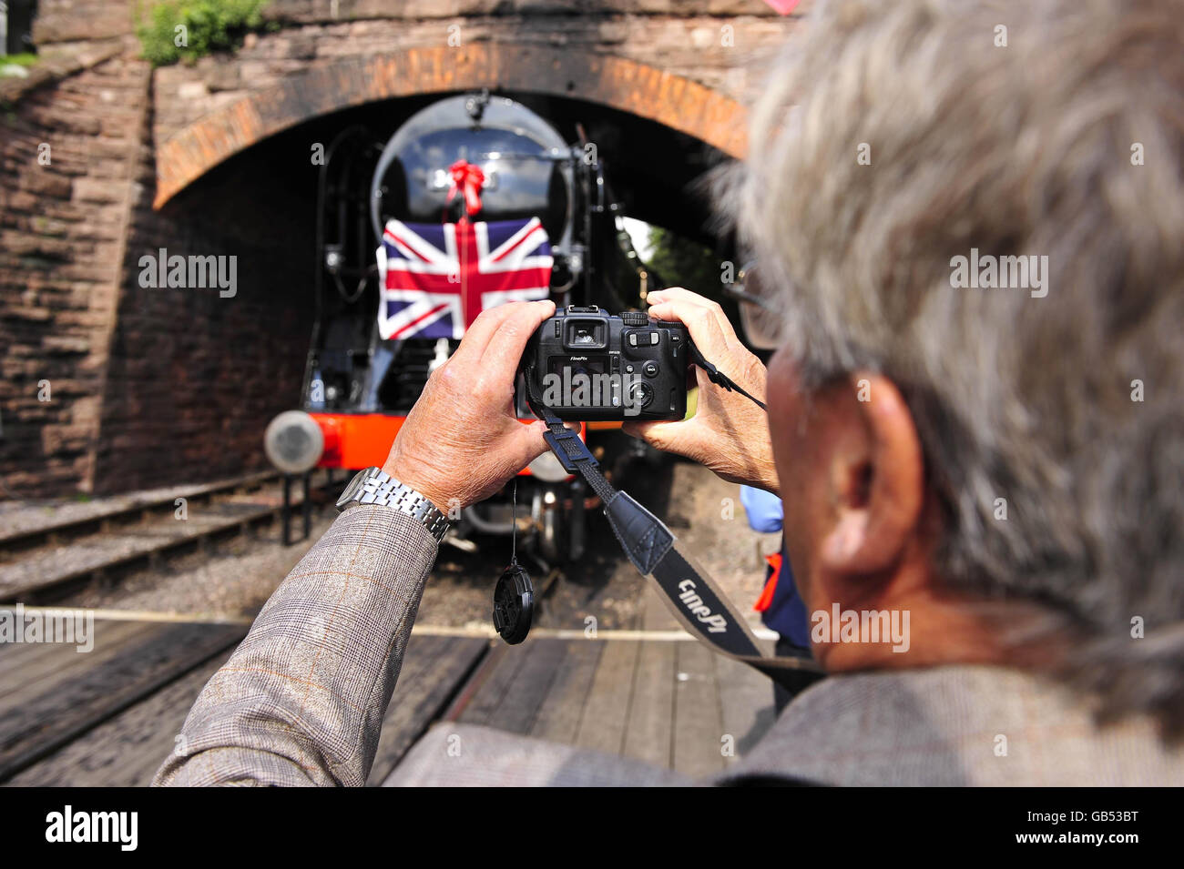 Ein Eisenbahnenthusiast fotografiert nach einem umfangreichen Renovierungsprojekt die Lancierung der neuesten Lok der Southern Railway West Country Class Nr. 34046 namens Braunton im Bahnhof Lydeard bei Taunton, Somerset. Stockfoto