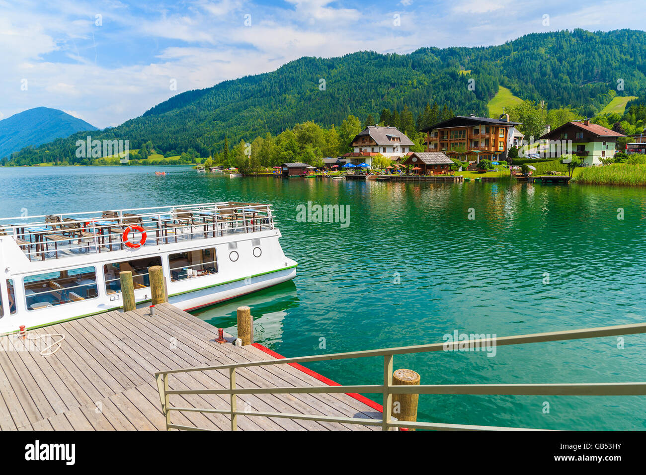 Gehweg zum Pier mit touristischen Bootsanlegestelle Pier am Ufer des Weißensee im Sommerlandschaft der Alpen, Österreich Stockfoto
