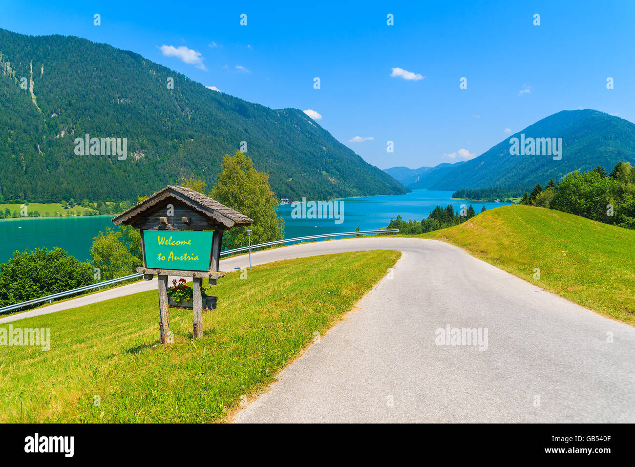 Blick auf Weißensee mit Schild entlang einer Straße mit Worten "Willkommen Österreich" Gruß gemalt an Bord, Österreich Stockfoto