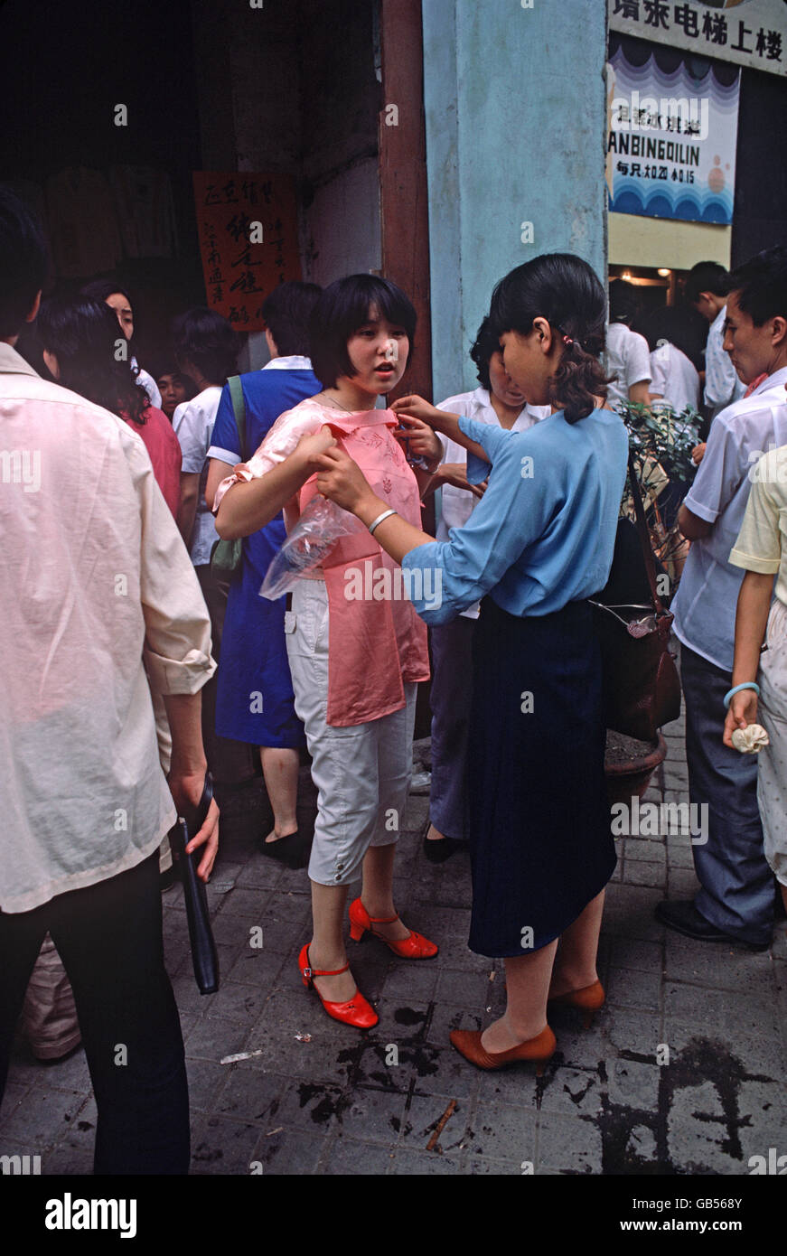 Chinesische Frau ausprobieren Kleidung im Markt Chengdu, Provinz Sichuan, China Stockfoto