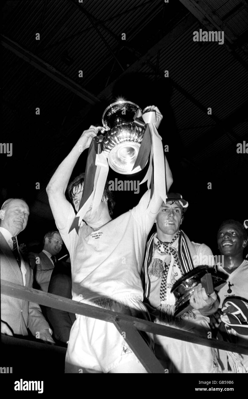 (L-R) Tottenham Hotspur Kapitän Steve Perryman hält den FA Cup Nach dem Sieg seines Teams im Jahr 1-0 als Teamkollege Graham Roberts Klammert sich an die Basis der Trophäe Stockfoto