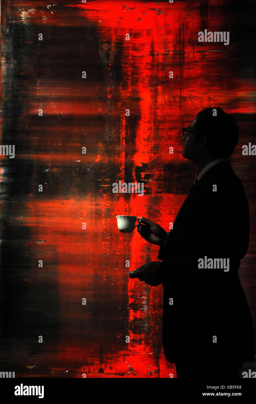 Ein Mitarbeiter blickt auf das abstrakte Bild (Rot) von Gerhard Richter in Sothebys Londoner Auktionsräumen. Stockfoto