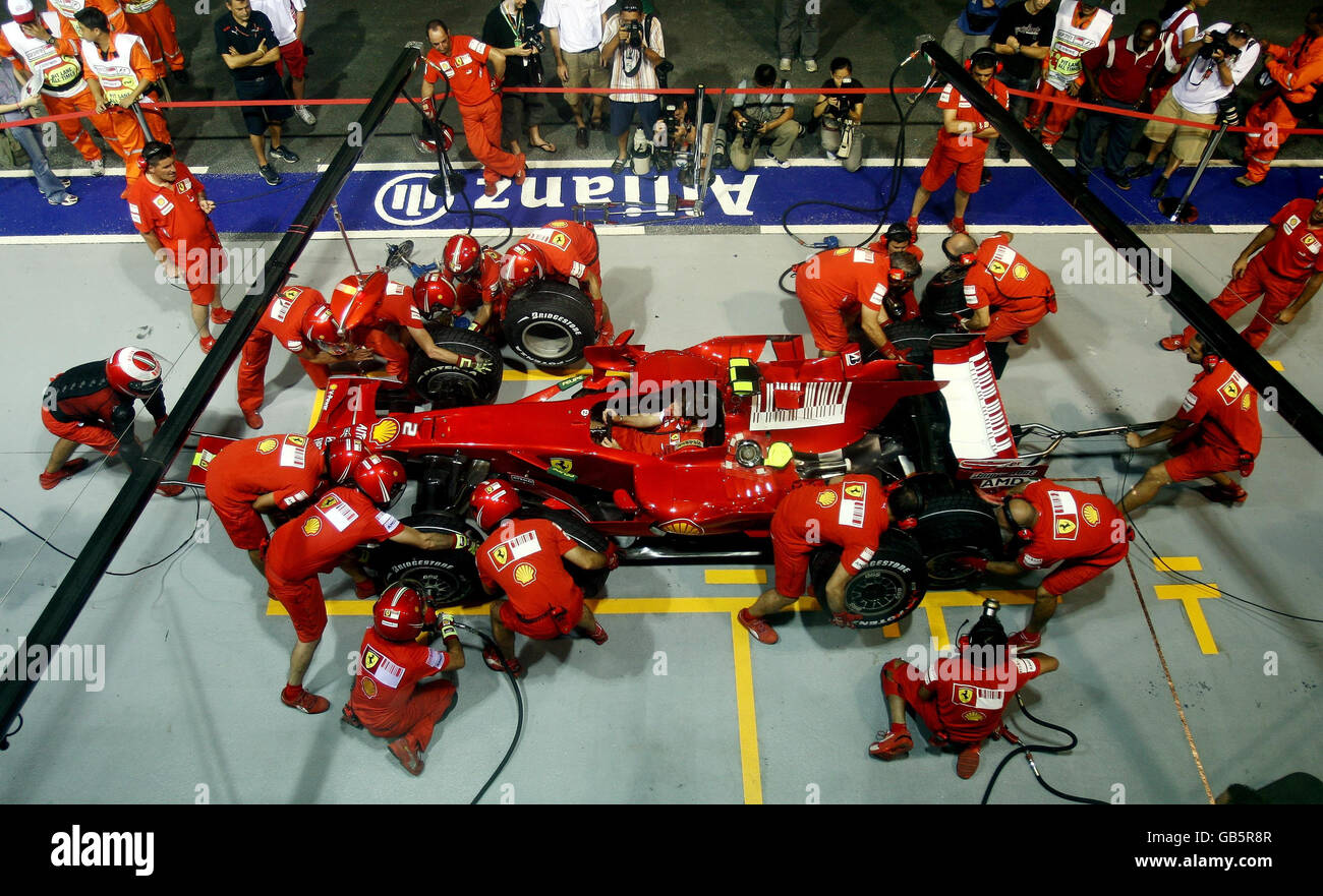 Ferrari-Mechaniker üben ihre Boxenstopps in der Boxengasse vor dem Singtel Singapore Grand Prix im Marina Bay Circuit Park in Singapur. Stockfoto