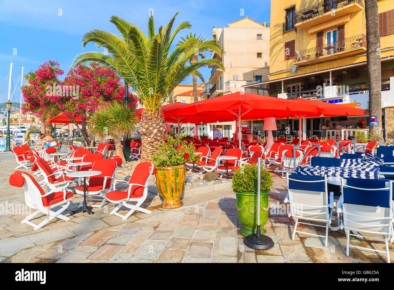 CALVI, Korsika - 29. Juni 2015: Stühle und Tische des Restaurants im Hafen von Calvi. Diese Stadt hat luxuriöse Marina und ist sehr Stockfoto