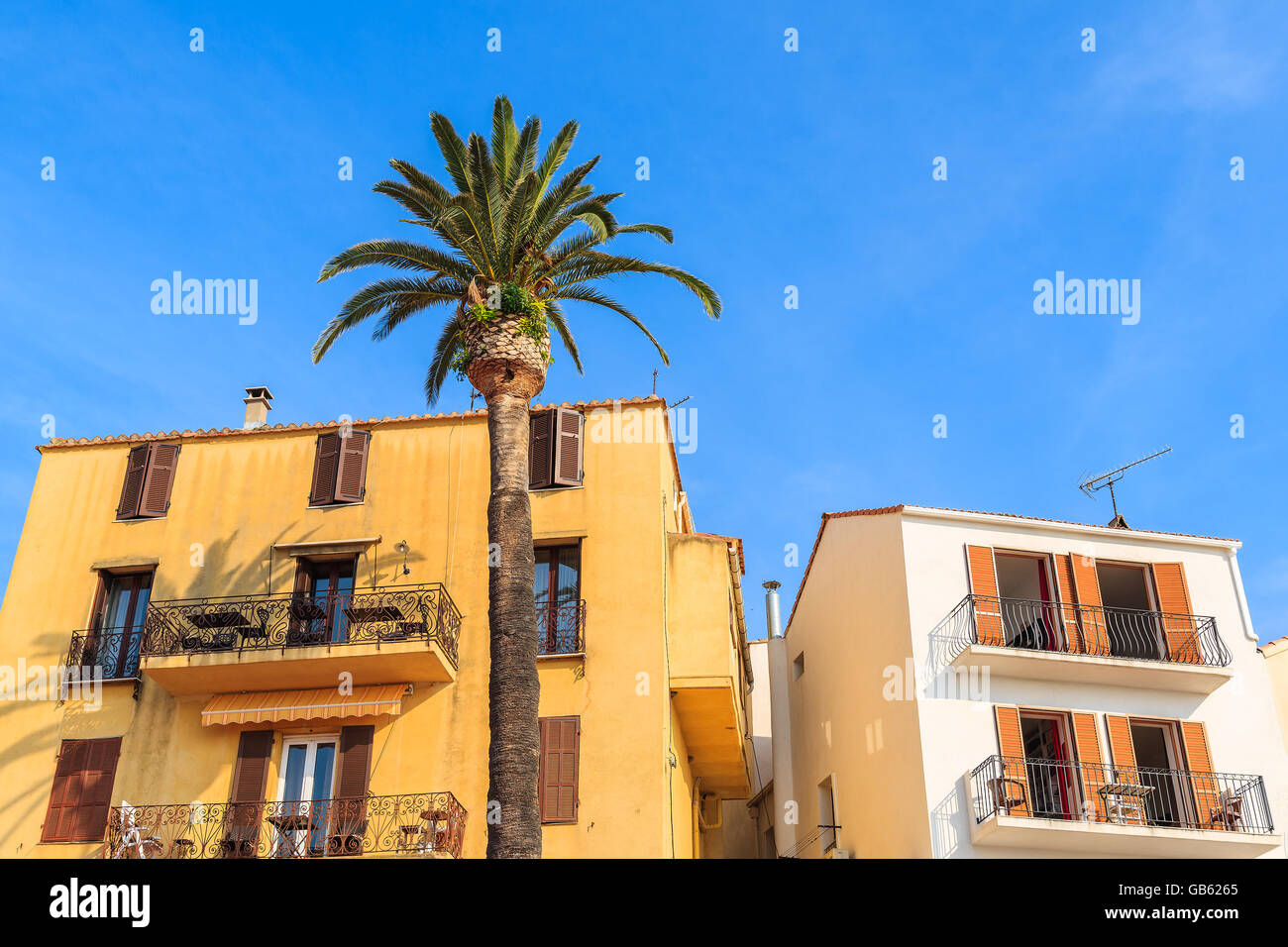 Typische Häuser mit Stühlen auf dem Balkon in der Stadt Calvi, Korsika, Frankreich Stockfoto