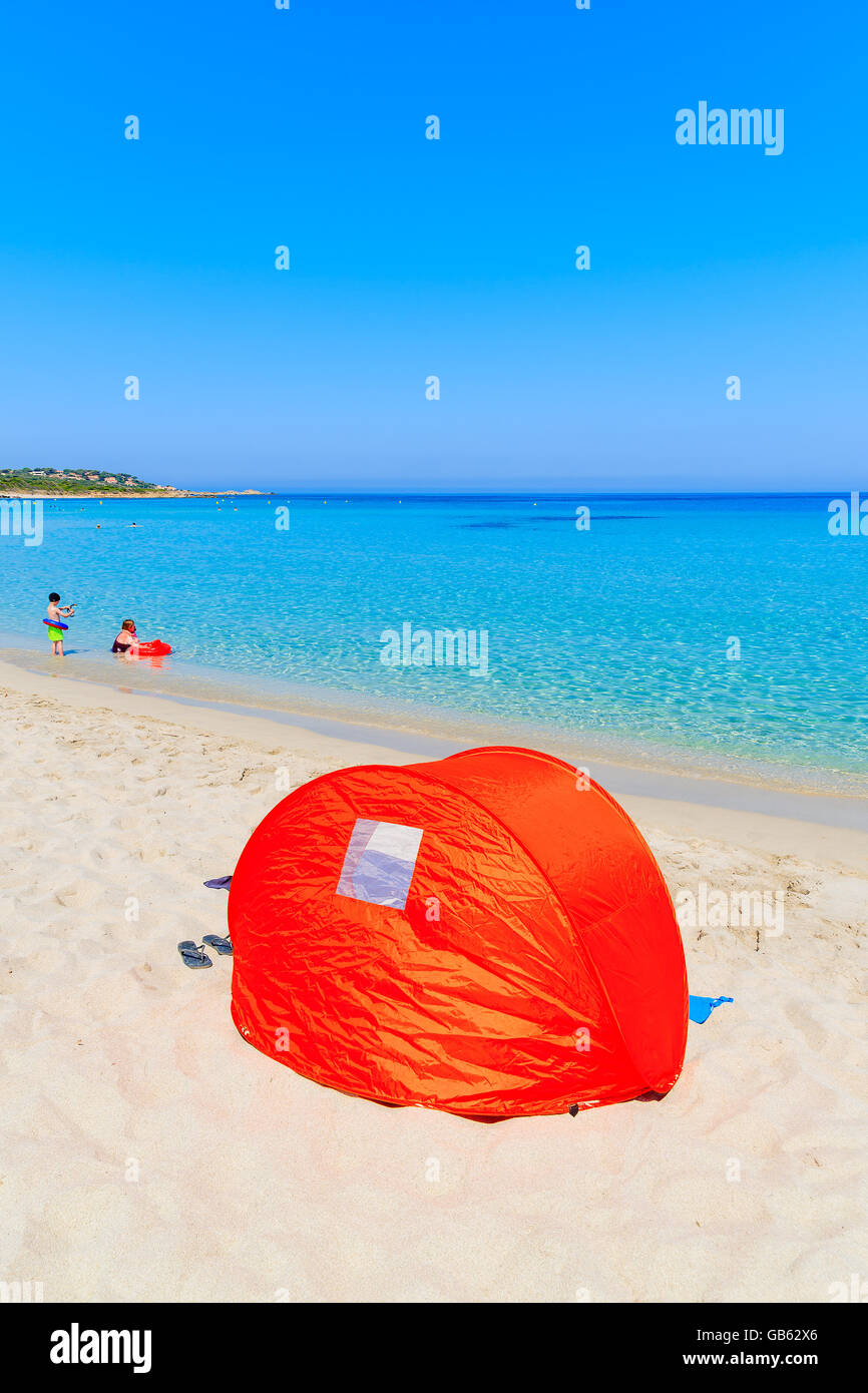 Sonnenschutz-Zelt am Bodri Sandstrand und Familie Entspannung in Wasser, Korsika, Frankreich Stockfoto