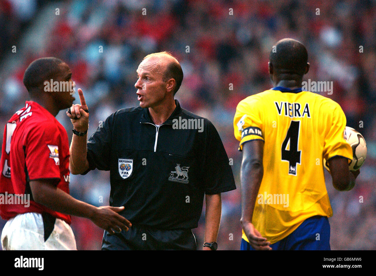 Quinton Fortune (l) von Manchester United bittet um den Ball zurück Von Arsenals Patrick Vieira (r) als Schiedsrichter Steve Bennett schaut Ein Stockfoto