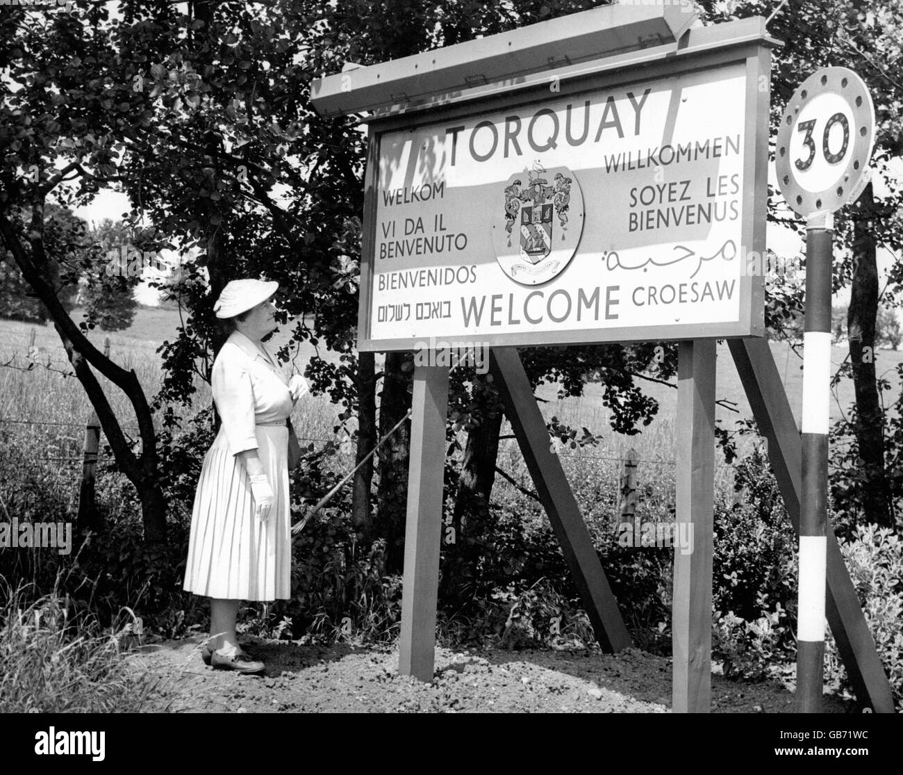 Besucher aus aller Welt werden in Torquay willkommen geheißen. Das mehrsprachige Schild sorgt dafür, dass auch diejenigen aus Übersee wissen, dass sie im beliebten Küstenresort South Devon willkommen sind. Stockfoto