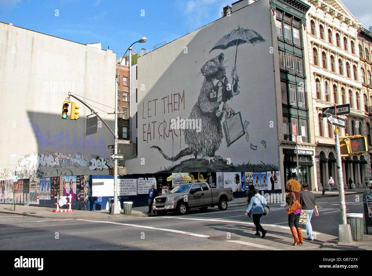 Ein großes Wandbild einer Ratte, die eine Krawatte trägt und eine Aktentasche an einer Wand auf der Howard St und dem Broadway in New York City trägt, ist es aber das jüngste Werk des schwer fassbaren britischen Straßenkünstlers Banksy in New York. Stockfoto