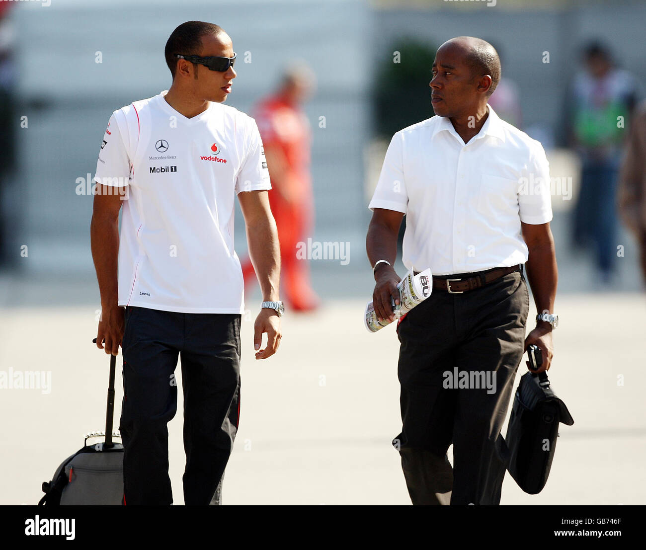 McLaren Mercedes-Pilot Lewis Hamilton (links) geht mit seinem Vater Anthony Hamilton (rechts) auf dem Shanghai International Circuit, China, das Fahrerlager hinunter. Stockfoto