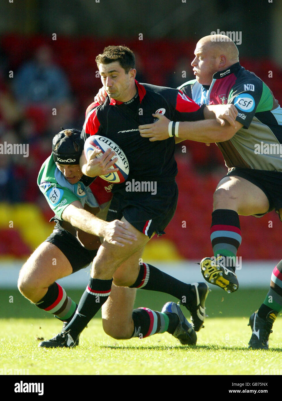 Rugby Union - Zurich Premiership - Saracens / Harlequins. Kevin Sorrell von Saracens wird von Ceri Jones und Jim Evans von Harlequins' gehalten Stockfoto