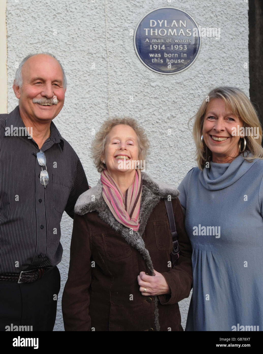 Aeronwy Ellis (Mitte) steht vor dem Haus, in dem ihr Vater Dylan Thomas mit den Restauratoren Geoff und Anne Haden in Swansea geboren wurde. Das Haus wurde heute, an seinem 94. Geburtstag, der Öffentlichkeit enthüllt. Stockfoto