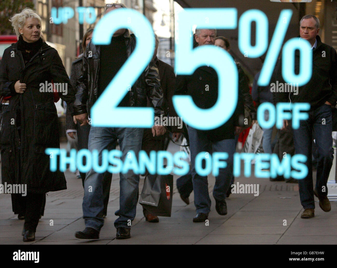 Die Käufer spiegeln sich in einem Verkaufsschild im Fenster des House of Fraser, Oxford Street, im Zentrum von London wider. Stockfoto