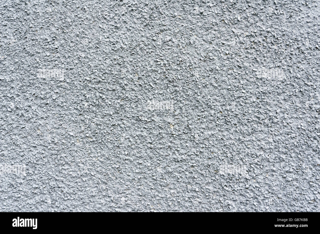 Graue Stuck Wand eingebettet mit kleinen eckigen Steinen Stockfoto
