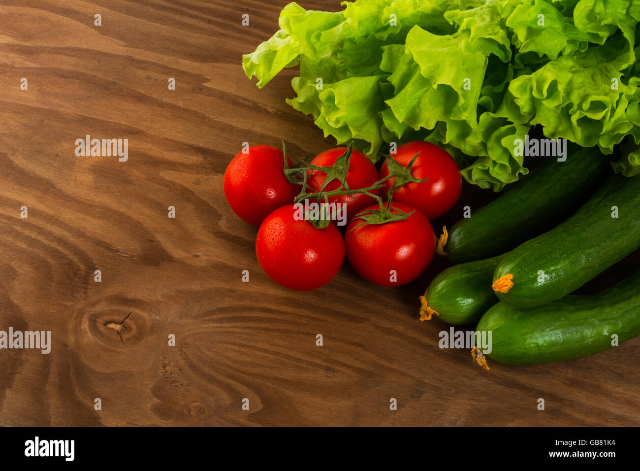 Gurke und Kirschtomaten auf Holztisch Tomate.  Gurke.  Reife Gemüse. Frisches Gemüse. Cherry-Tomate. Gesunde Ernährung. Stockfoto