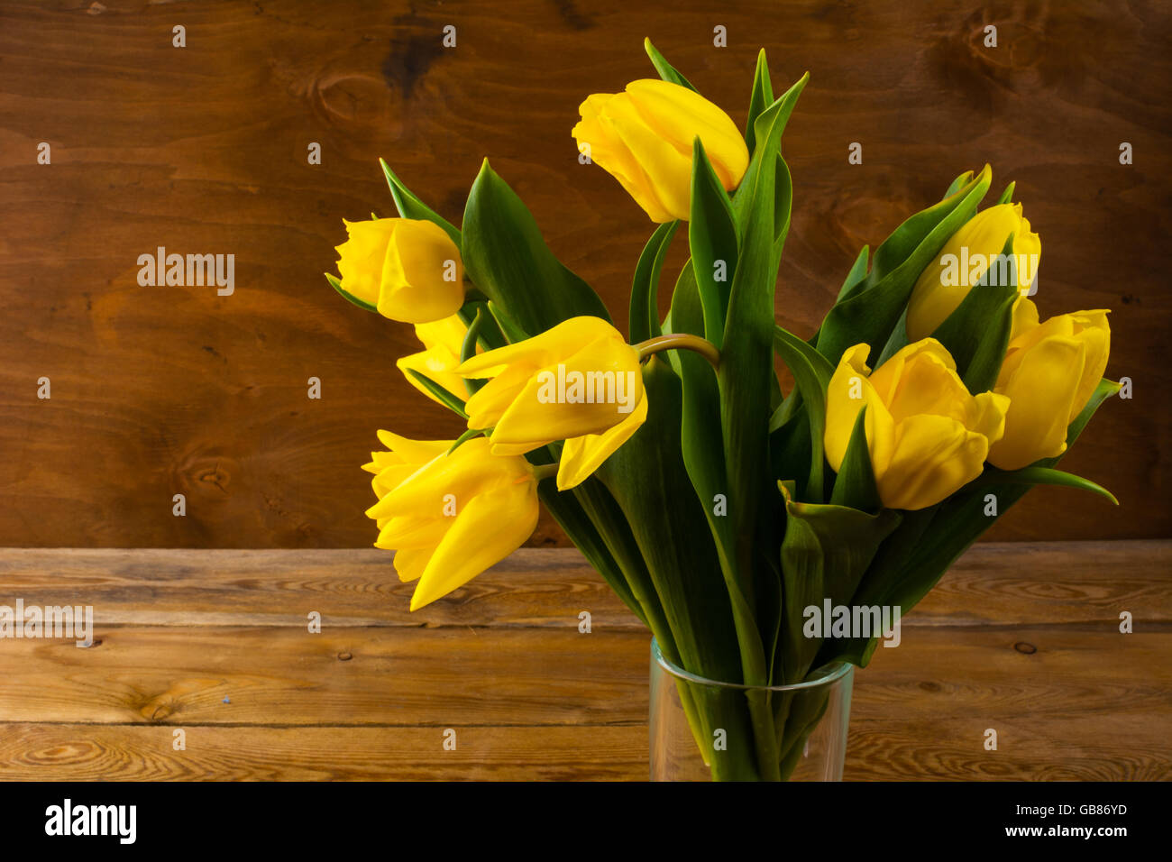 Gelbe Tulpen Strauß auf hölzernen Hintergrund. Blumen-Postkarte. Frühling Blumen. Blumengrüße. Stockfoto