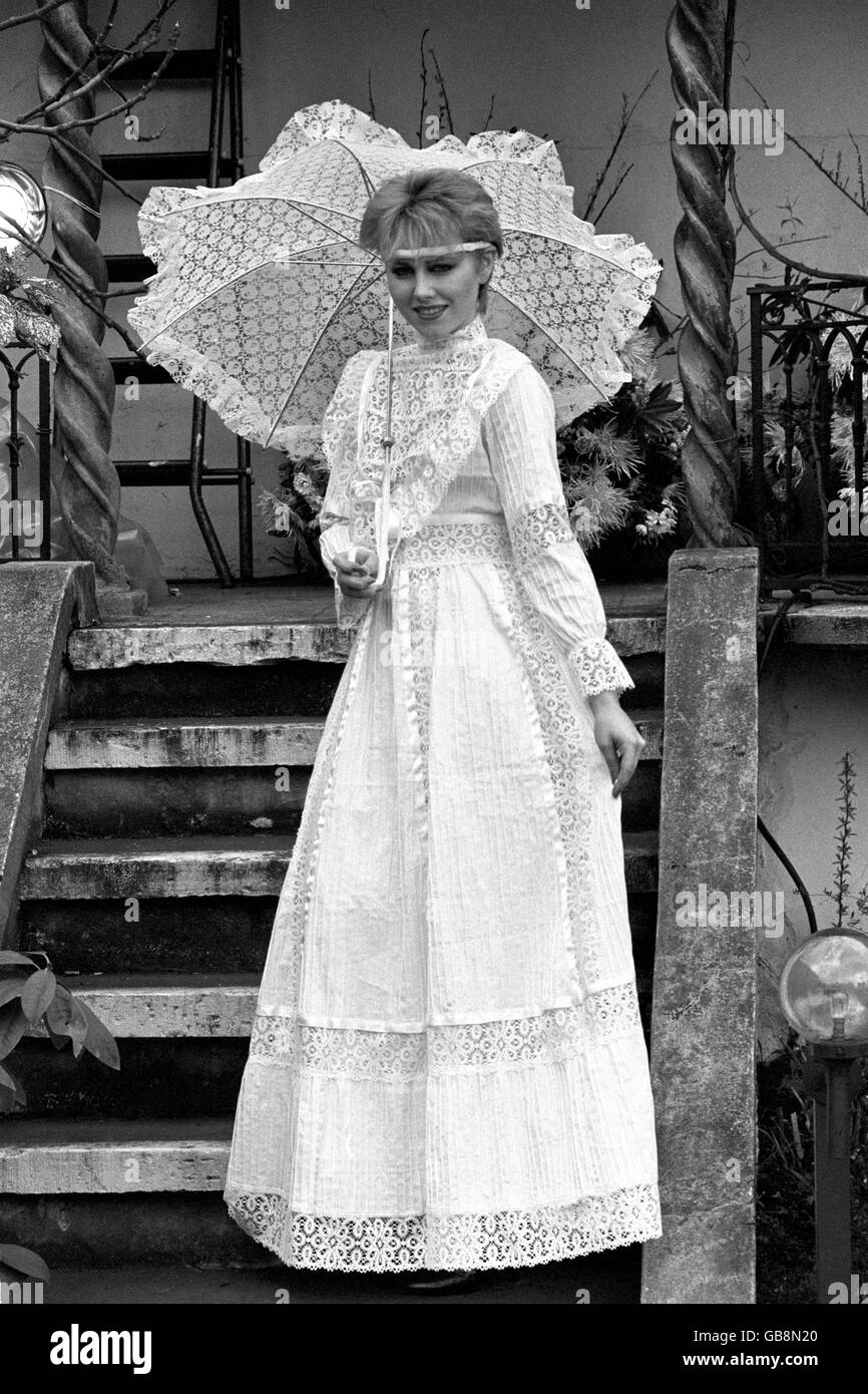 Modell Kerri zeigt dieses demure bodenlange Kleid von Aries Import mit diesem bis zur Minute Prinzessin von Wales Stil Rüschen Mieder, ideal für Sommer Garten Partys. Stockfoto