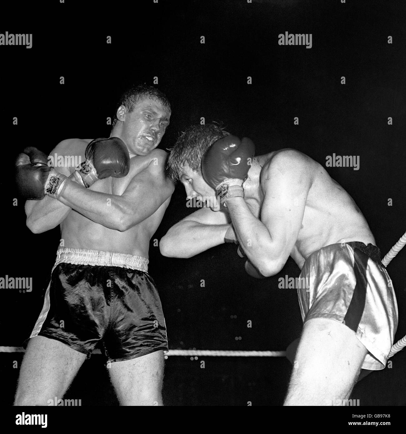 Boxen - Schwergewicht-Division - Billy Walker / Johnny Prescott - Empire Pool - Wembley. Johnny Prescott verdeckt sich von einem zweihändigen Angriff von Billy Walker in der zehnten und letzten Runde. Stockfoto