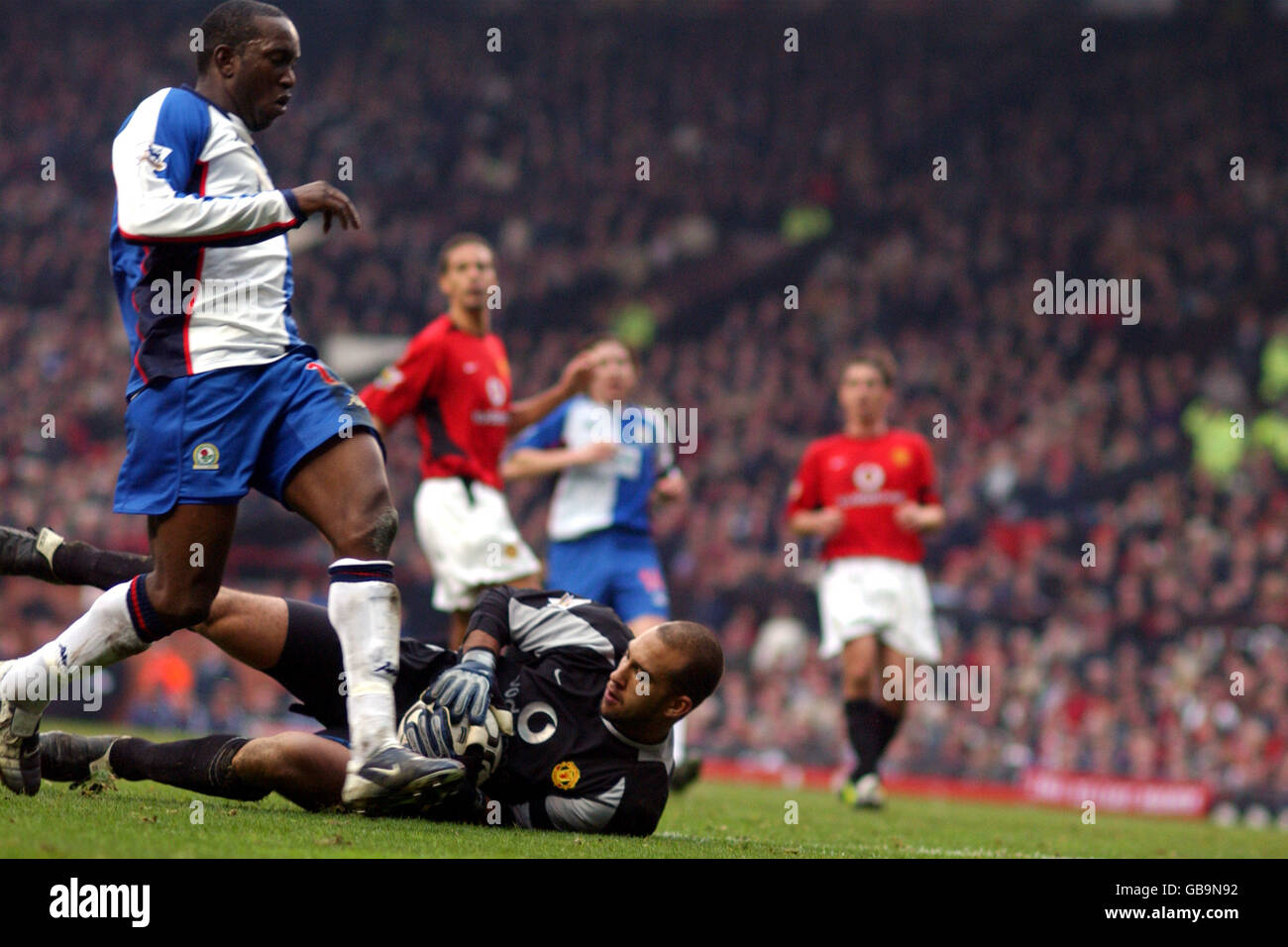 Manchester United Torhüter Tim Howard rettet vor den Füßen „Dwight Yorke“ Von Blackburn Rovers Stockfoto