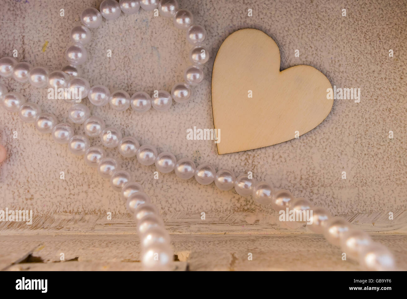 Ein Herz aus Holz und eine Kette als Dekoration auf eine griechische Taufe. Stockfoto