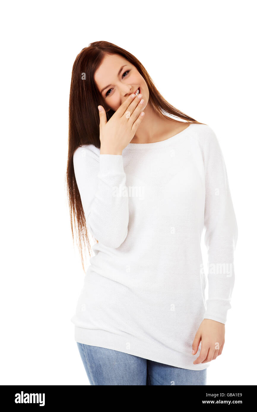 Junge Frau kichert über den Mund mit der hand Stockfoto