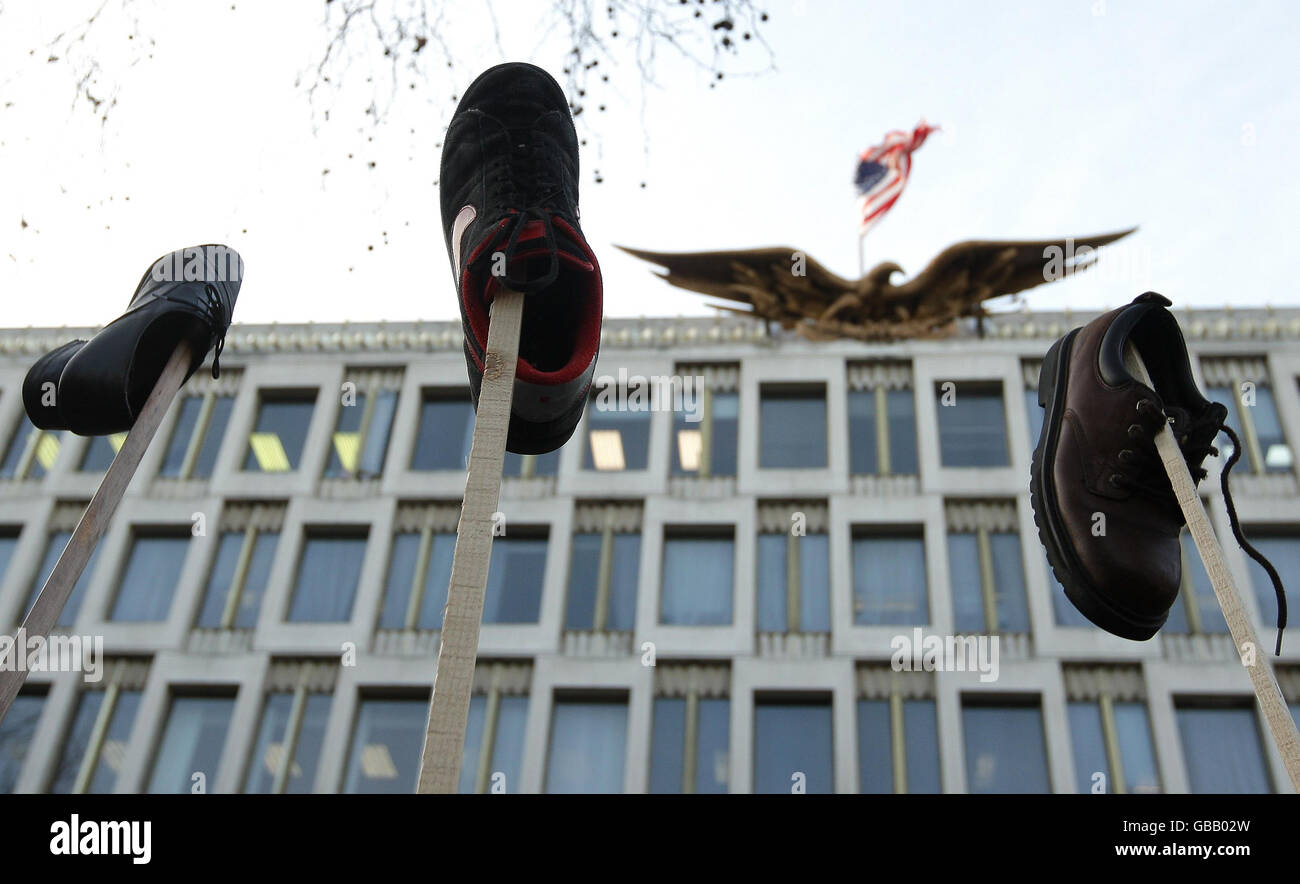 Demonstranten winken Schuhe in die Luft vor der amerikanischen Botschaft am Grosvenor Square, London, als Teil einer Demonstration zur Unterstützung des irakischen Journalisten Muntadar al-Zaidi, der festgenommen wurde, weil er einen Schuh auf US-Präsident George W. Bush geworfen hatte. Stockfoto