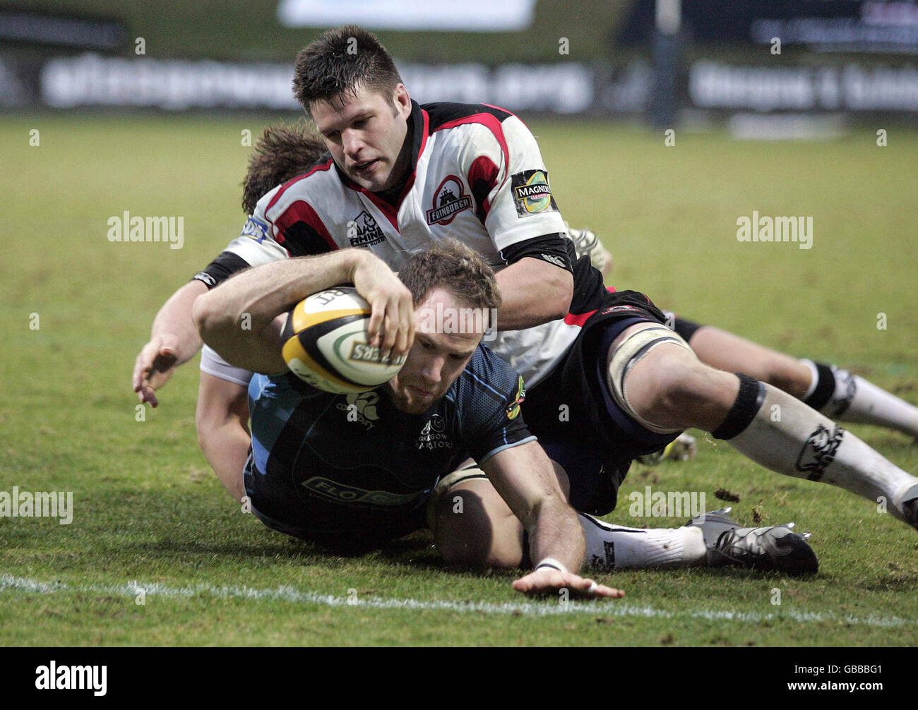 Glasgow's Graeme Morrison entgeht einem Tackle von Edinburghs Allister Hogg, um während des Spiels der Magners League in der Firhill Arena, Glasgow, einen ersten Halbversuch zu erzielen. Stockfoto
