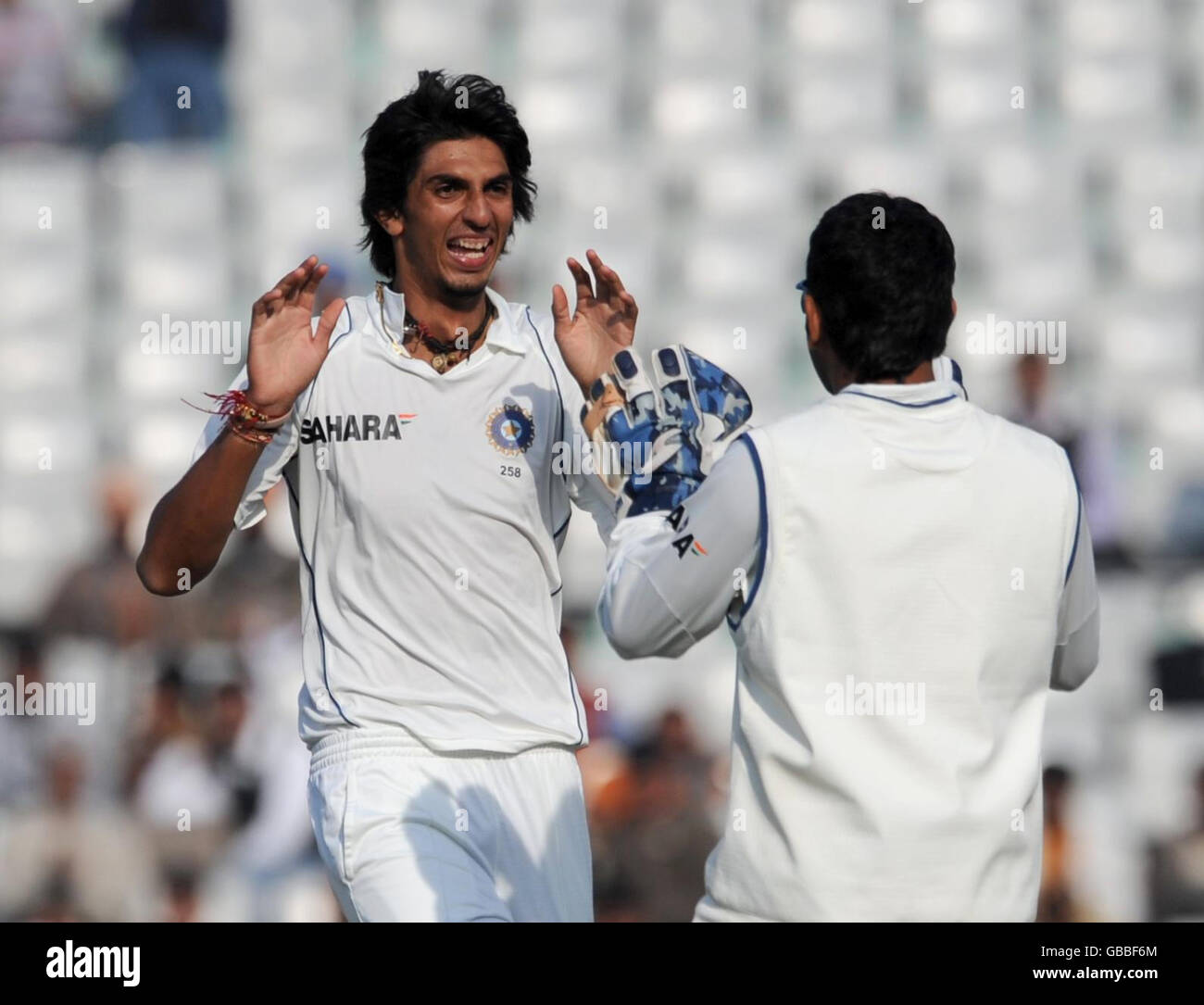 Ishant Sharma (links) feiert, dass Alastair Cook am fünften Tag des zweiten Tests im Punjab Cricket Association Stadium, Mohali, Indien, vom VVS Laxman für 10 gefangen wird. Stockfoto