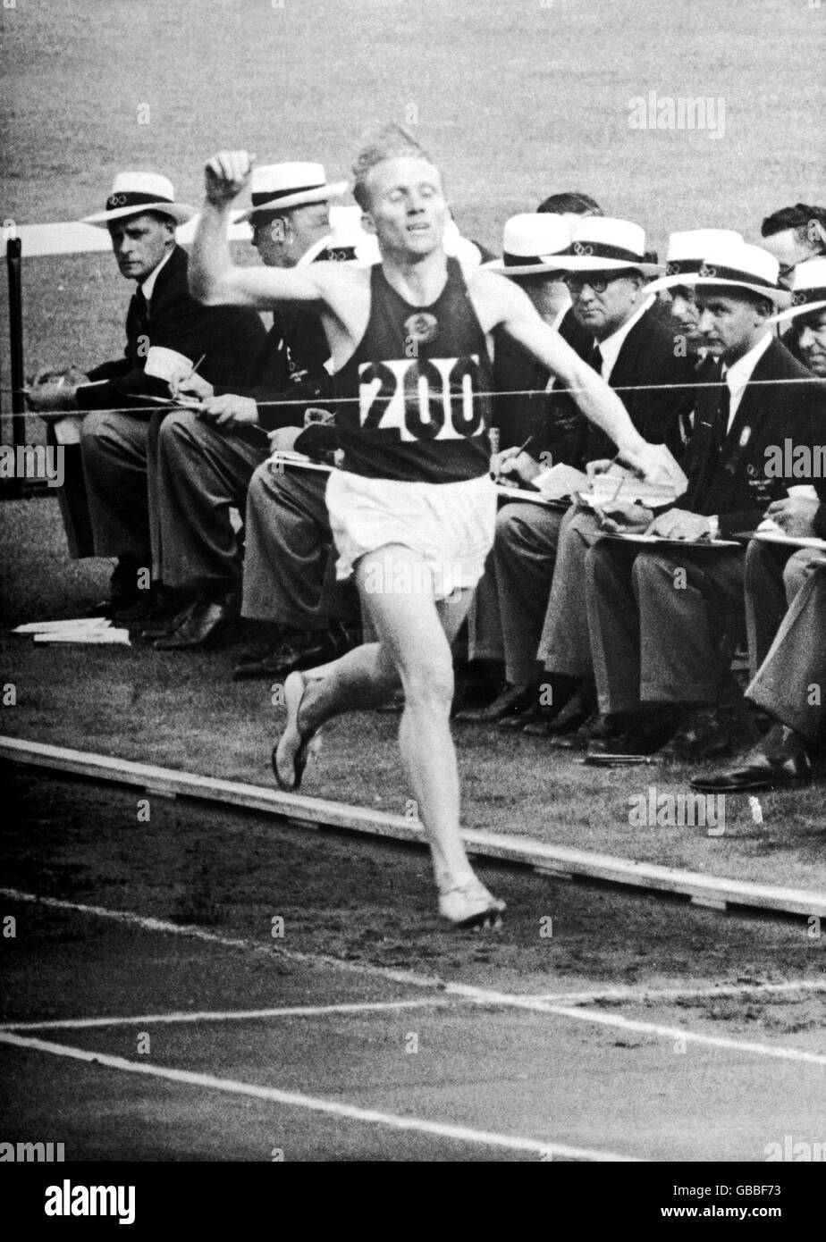 Leichtathletik - Olympische Spiele 1956 in Melbourne - Finale der Männer über 5000 Meter. Wladimir Kuts der UdSSR feiert, als er die Grenze überquert, um Gold zu gewinnen Stockfoto