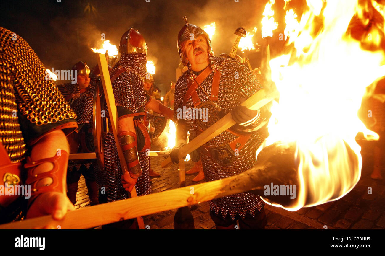 Wikinger zünden ihre Fackeln vor der Fackelparade im Rahmen der Hogmanay-Feierlichkeiten in Edinburgh an. Stockfoto