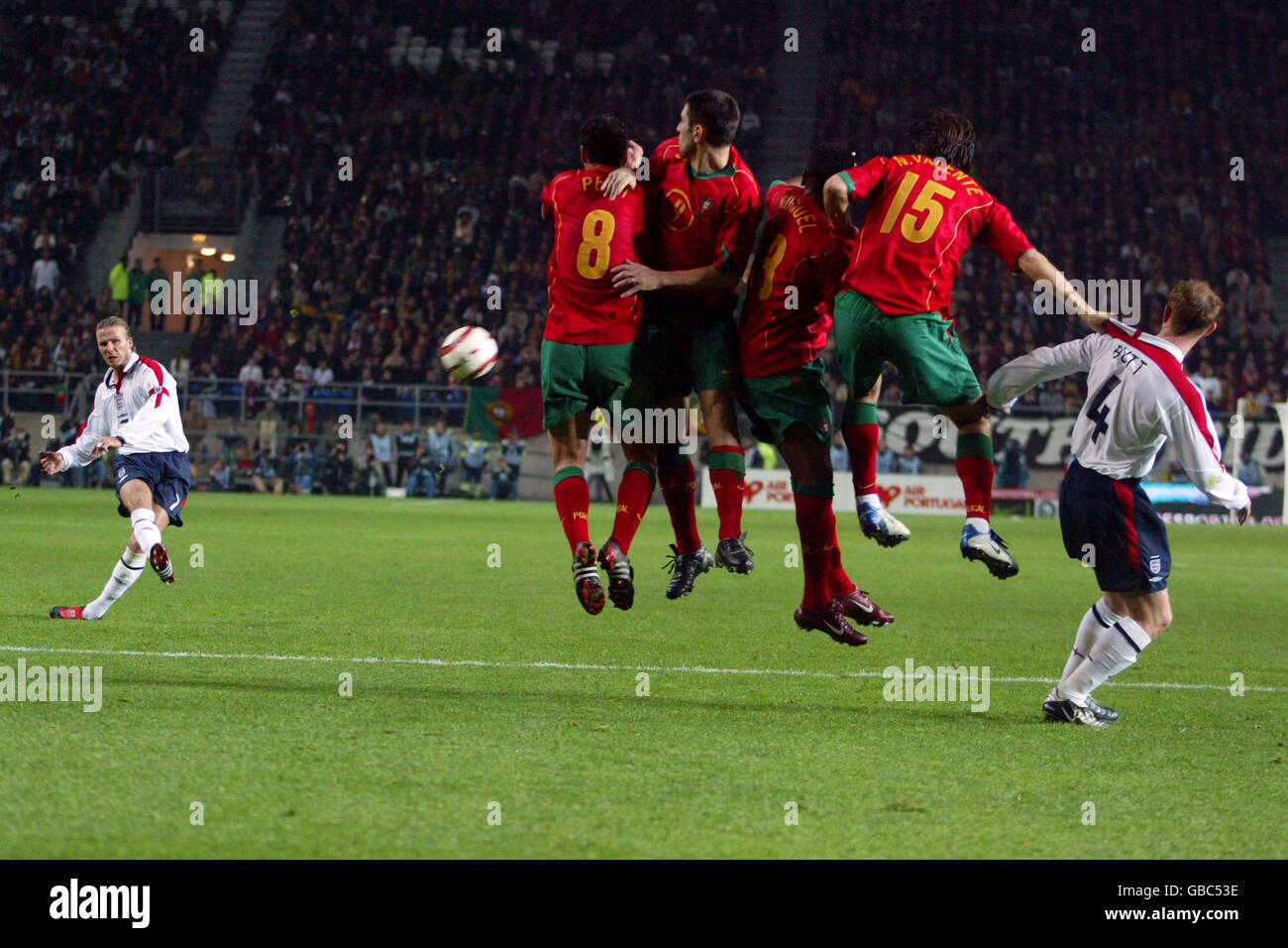 Fußball - International freundlich - Portugal gegen England. Der englische David Beckham (l.) rollt einen Freistoß um die portugiesische Verteidigungsmauer Stockfoto