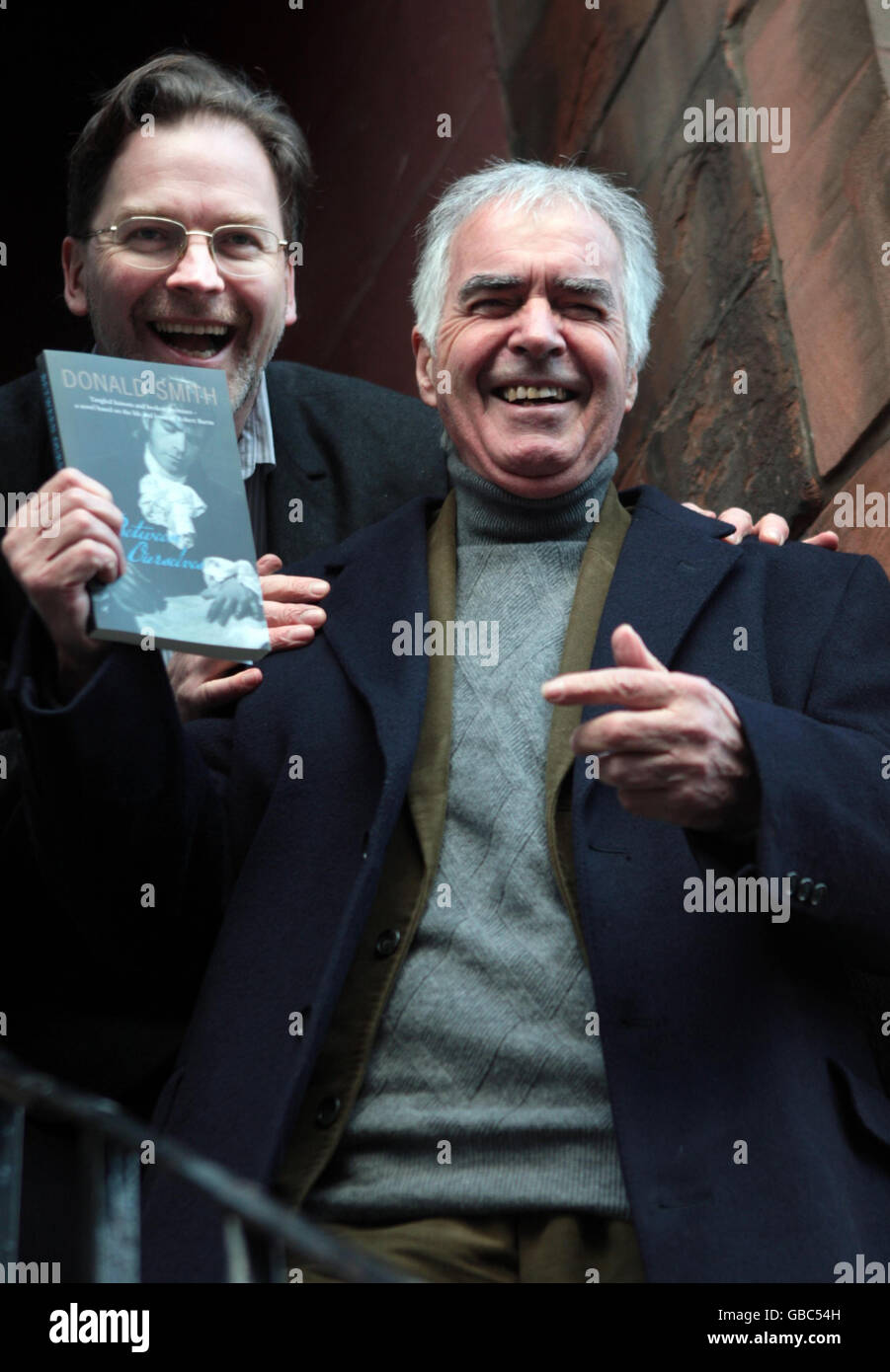 Der Burns-Performer John Cairney (vorne) hilft, ein neues Buch über Robert Burns von Donald Smith (hinten) zu veröffentlichen, das sich unter dem Titel Between Ourselves on Edinburgh's High Street befindet. Stockfoto