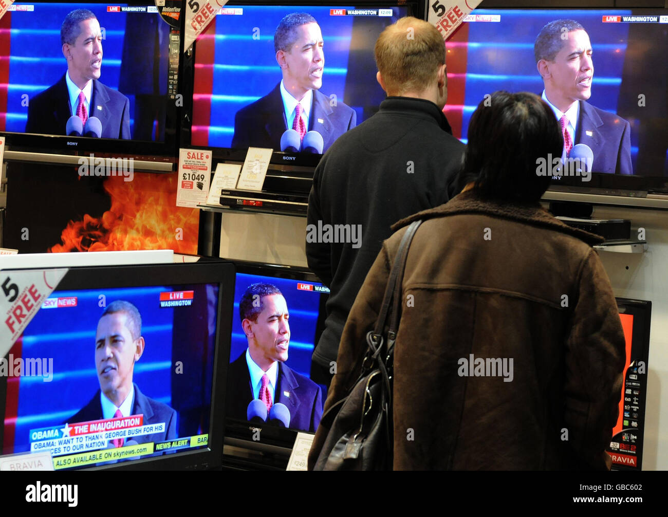 Kunden beobachten, wie Barack Obama seine Rede zur Amtseinführung des Präsidenten in einem Elektrogeschäft in Chelmsford, Essex, hält. Stockfoto