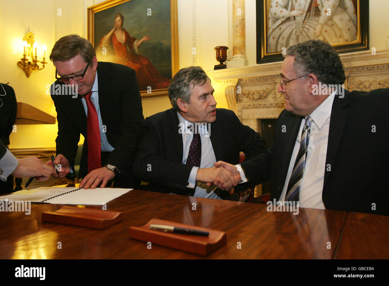 (Mann links: Name nicht bekannt) Premierminister Gordon Brown (Mitte) und der Vorsitzende des Leicestershire County Council, Ratsmitglied David Parsons (rechts), schütteln sich die Hände, nachdem er ein Mehrgebiet-Abkommen für Leicester in der Downing Street 10 im Zentrum von London unterzeichnet hat. Stockfoto